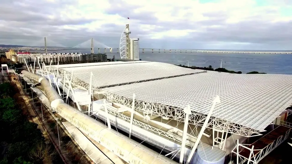 A wide view of a waterfront event venue and surrounding buildings in Lisbon.