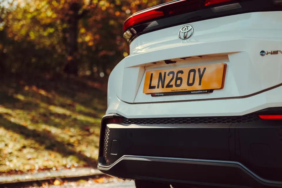 A white Toyota ready for handover, photographed outside in the autumn sunshine.
